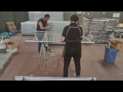 Die Arbeiter verbinden den Zaun und das Rahmenrohr mit Draht.